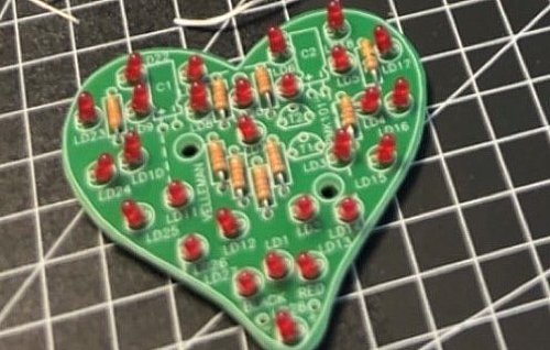 Ein herzförmiges elektronisches Bauteil, das beim PLATH Girls' und Boys' Day 2024 in Hamburg gelötet wurde, liegt auf einer Arbeitsfläche. Die Lötstellen sind sauber und deutlich sichtbar, und das fertige Bauteil strahlt einen Hauch von Stolz und handwerklicher Präzision aus. 