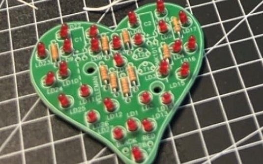 A heart-shaped electronic component that was soldered at the PLATH Girls' and Boys' Day 2024 in Hamburg lies on a work surface. The soldered joints are clean and clearly visible, and the finished component exudes an air of pride and precision craftsmanship. 